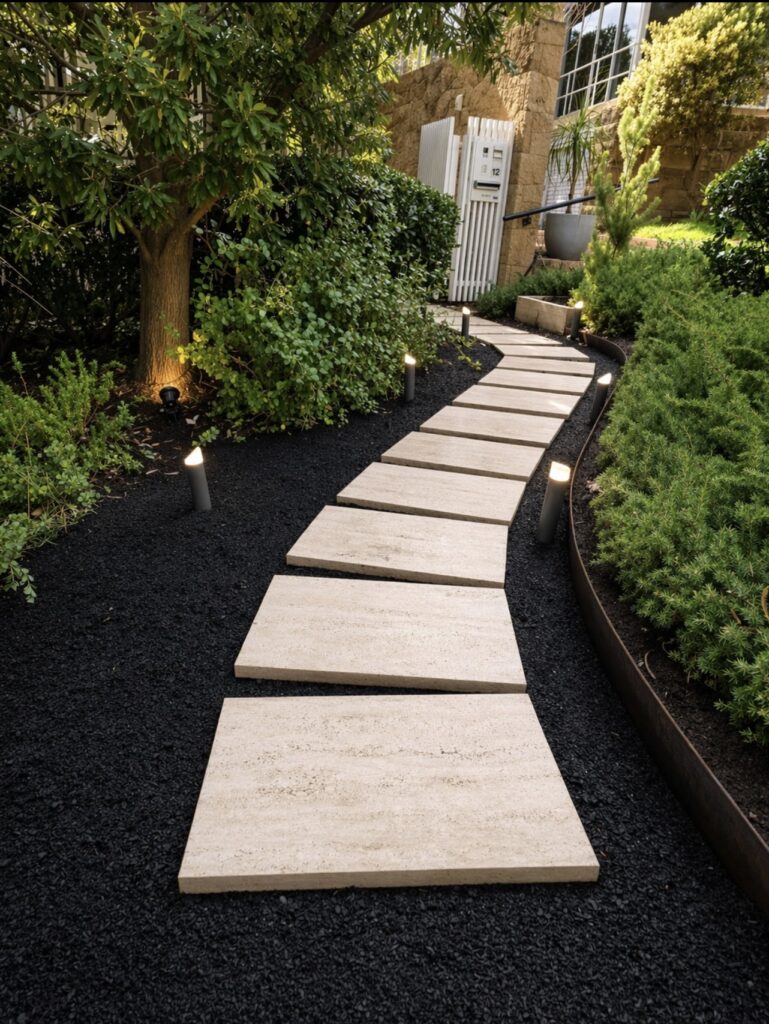 Porcelain stepping stone pathway through a landscapes garden with feature lighting and steel edging. Cottesloe Perth.