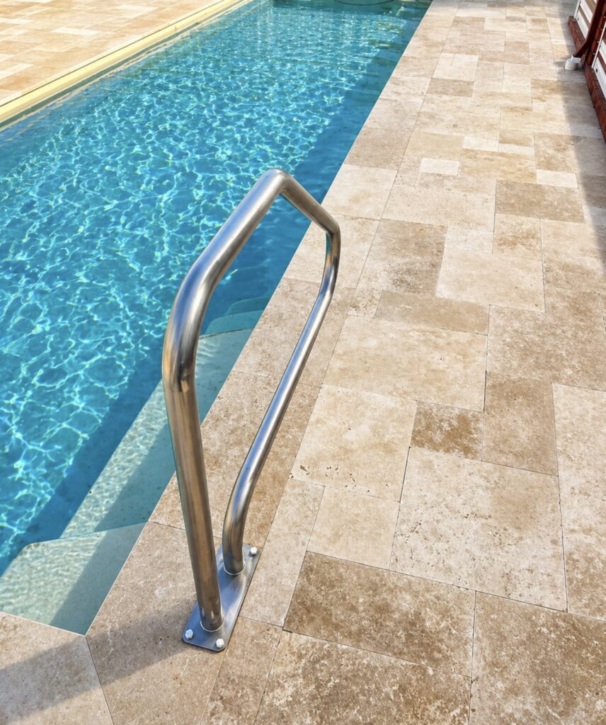Travertine pool surround and paving installation with silver pool hand rail installation in Woodvale Perth. 