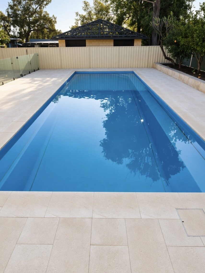 Limestone paving to pool area with glass pool fencing and a custom flush access lid  